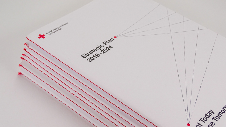 Irish Red Cross, Strategic Plan 2019–2024 design by UNIT. Studio Dublin. Detail showing red saddle-stitched cover.